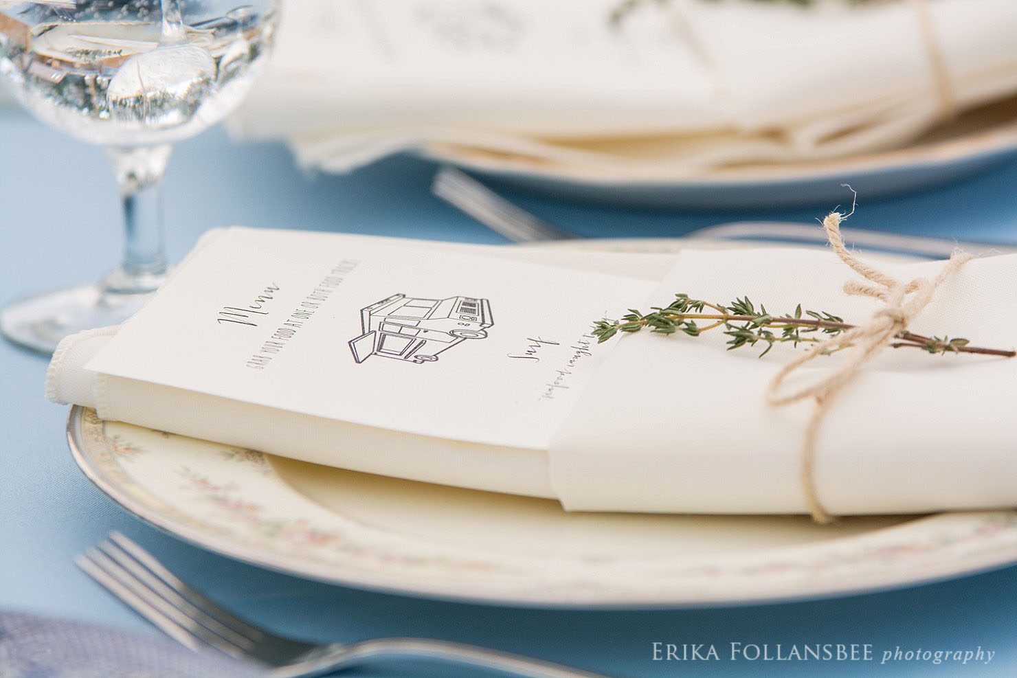 wedding menu tucked into napkin tied with twine and a sprig of thyme