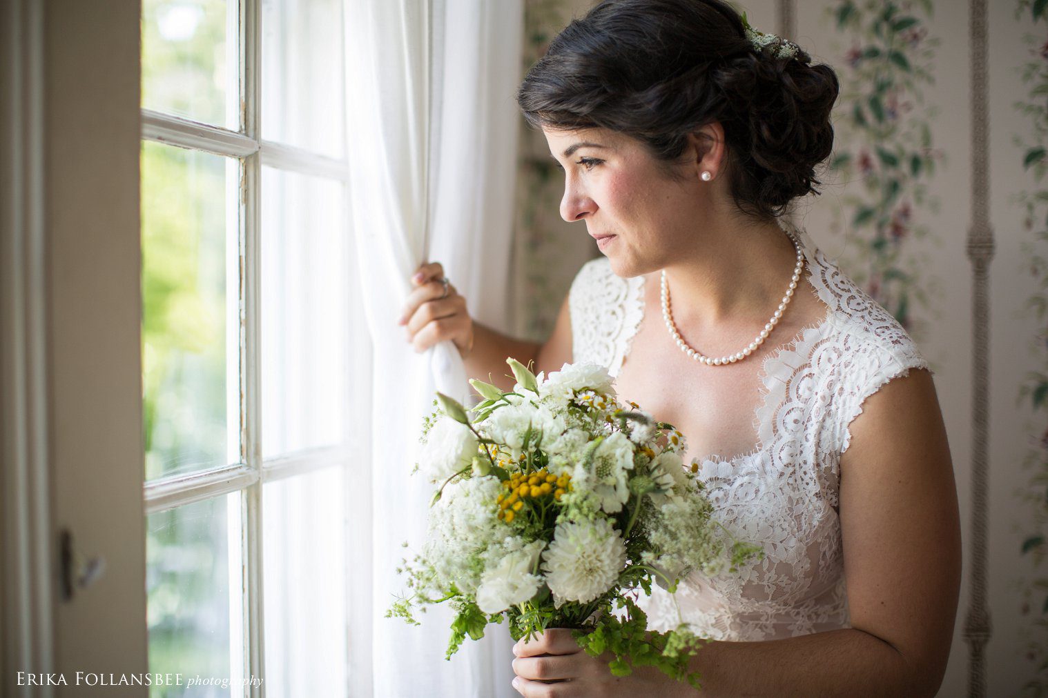 Bride looks out the window as she awaits her wedding ceremony | The Fells, NH