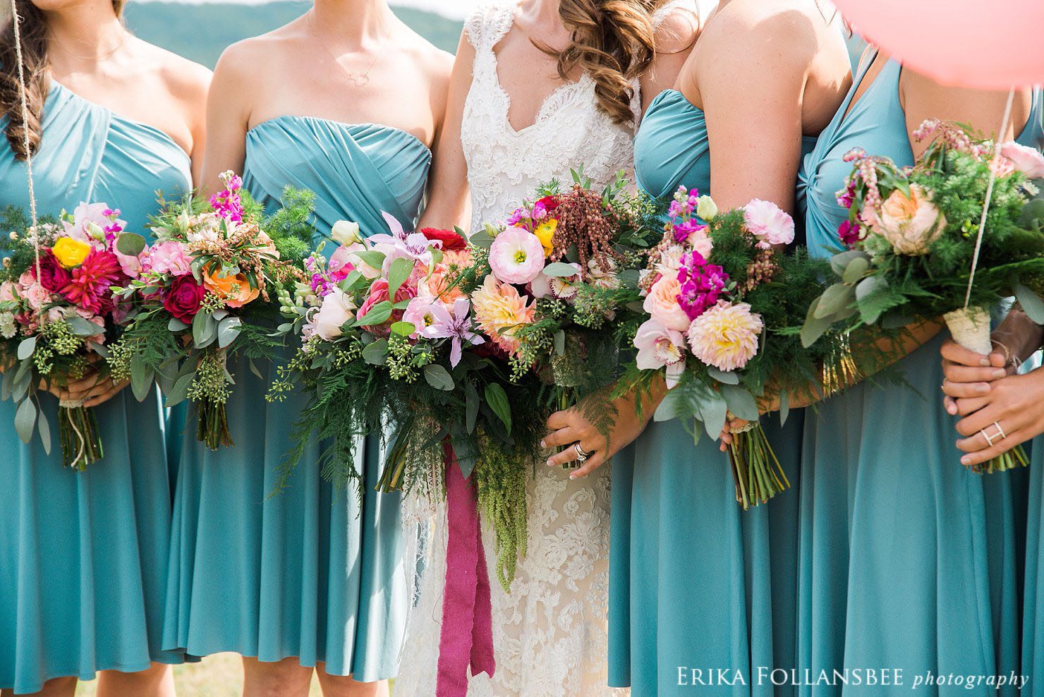 bride and bridesmaids in blue dresses with large, colorful bouquets