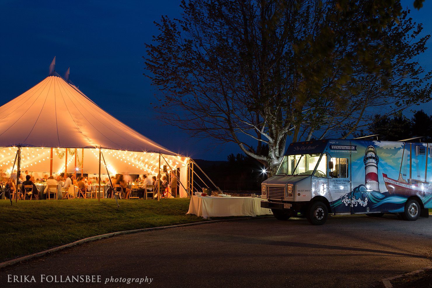 Nighttime photo of the tent all lit up with Cod Squad food truck parked in front.